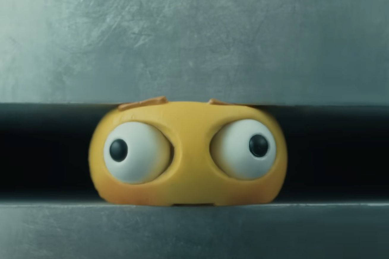 An image of an emoji crushed in a giant hydraulic press.